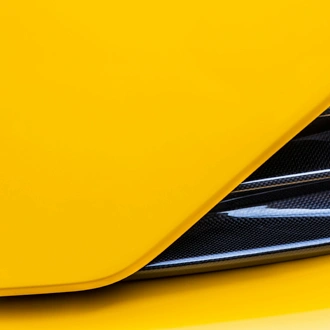 Detail of yellow Ferrari bodywork and carbon fiber vent 